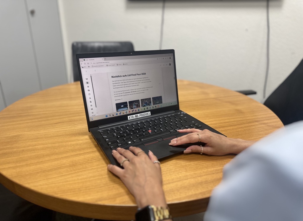 Mitarbeiterin nutzt Kibi Connect bei Alsco am Laptop im Besprechungsraum